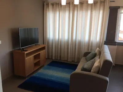 a living room with a couch and a flat screen tv at Apartamentos Sousa in Funchal