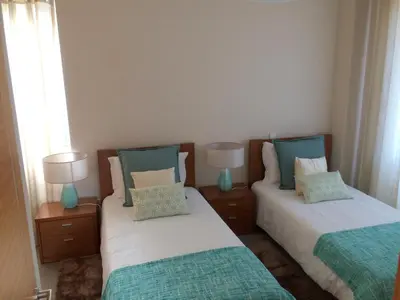 a bedroom with two beds with blue and white pillows at Apartamentos Sousa in Funchal