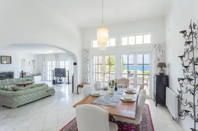 a dining room and living room with a table and chairs at Top Cliff Villa with Ocean View and Private Pool UP to 18 Guests in Burgau