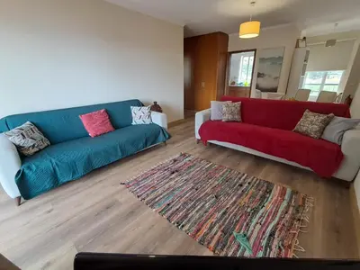 a living room with two couches and a rug at Apartamento Vai Vem in Madalena do Mar