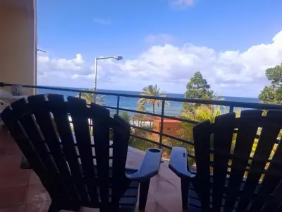 a balcony with two chairs and a view of the ocean at Apartamento Vai Vem in Madalena do Mar