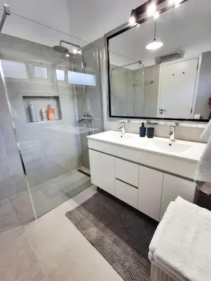 a white bathroom with a sink and a mirror at Bay View Apartment in Funchal