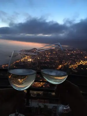 two glasses of wine sitting on top of a building at Bay View Apartment in Funchal