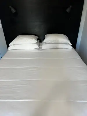 a large white bed with two pillows on it at The Loft Junction in Funchal