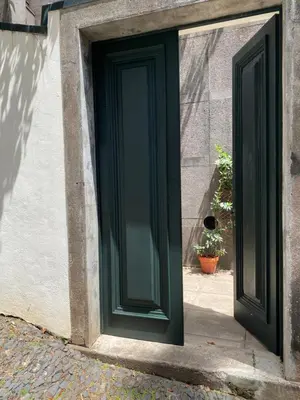 a green door on the side of a building at The Loft Junction in Funchal