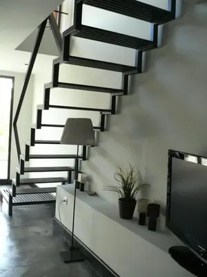 a living room with a staircase and a tv at The Loft Junction in Funchal