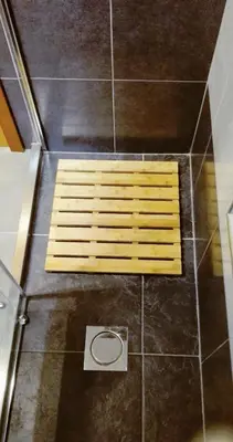 a shower with a wooden bench on the floor at Mericia's Gorgeous View in Funchal