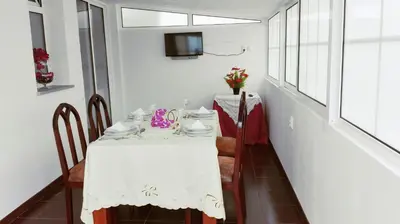 a dining room with a white table and a tv at Mericia's Gorgeous View in Funchal
