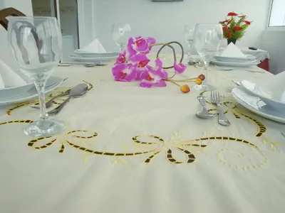 a table with a white table cloth with flowers and glasses at Mericia's Gorgeous View in Funchal
