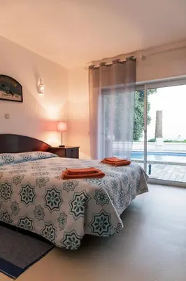 a bedroom with a bed and a large window at Great view to sea, villa with pool in Salema