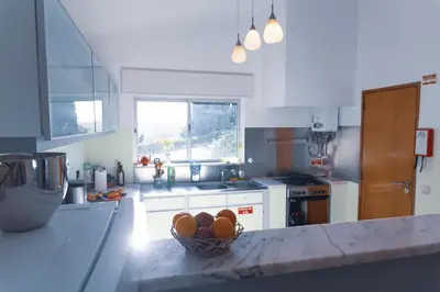 a kitchen with a bowl of fruit on a counter at Great view to sea, villa with pool in Salema