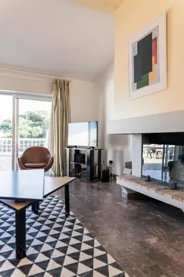 a living room with a table and a fireplace at Great view to sea, villa with pool in Salema