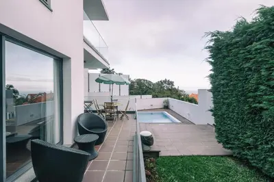 a patio with chairs and a swimming pool on a house at Casa Branca in Funchal