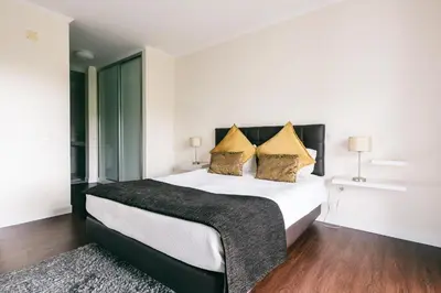 a bedroom with a large white bed with yellow pillows at Casa Branca in Funchal