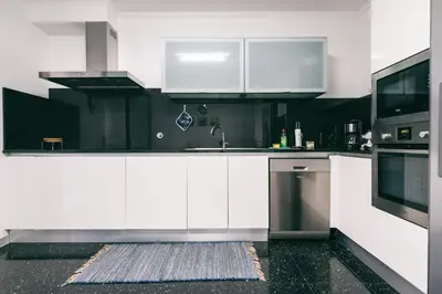 a kitchen with white cabinets and a sink at Casa Branca in Funchal