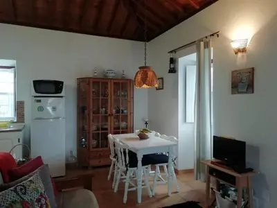 a living room with a table and a kitchen at Casa do Norte - Santa Maria in Norte