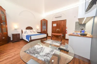 a bedroom with a bed and a glass table at Quinta da Paz in Caniço
