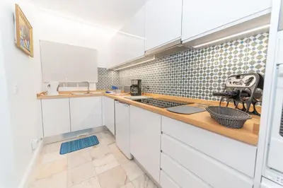 a kitchen with white cabinets and a counter top at Quinta da Paz in Caniço