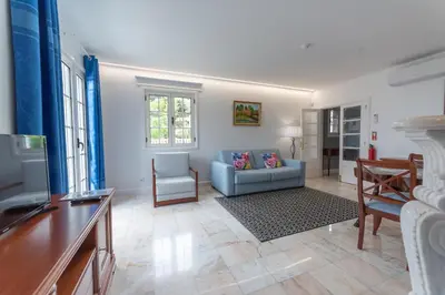 a living room with a blue couch and a table at Quinta da Paz in Caniço