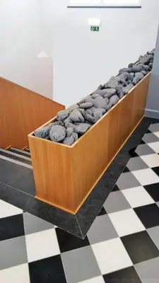 a bench filled with rocks on a checkered floor at The Marketplace by Storytellers in Funchal