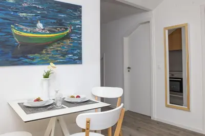 a dining room with a painting of a boat at The Marketplace by Storytellers in Funchal