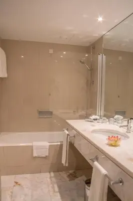 a bathroom with a tub and a sink and a shower at Pestana Madeira Beach Club in Funchal