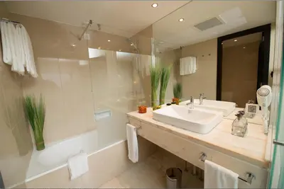 a bathroom with a sink and a bath tub and a sink at Pestana Madeira Beach Club in Funchal