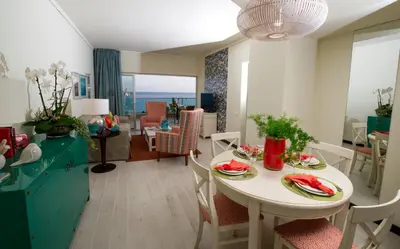 a kitchen and living room with a table and chairs at Pestana Madeira Beach Club in Funchal