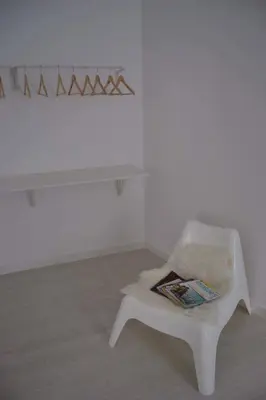 a white chair in a room with a white wall at Charming Apartment 101 in Funchal