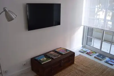 a room with a tv and a table with books at Charming Apartment 101 in Funchal