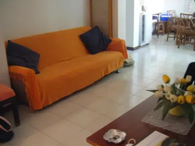 an orange couch in a living room with a table at Casa Mansa in Porto Santo