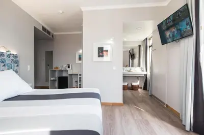 a bedroom with a white bed and a bathroom at Sé Boutique Hotel in Funchal