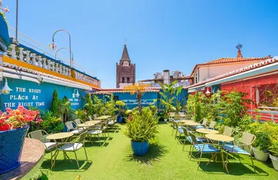 an outdoor patio with tables and chairs and plants at Sé Boutique Hotel in Funchal