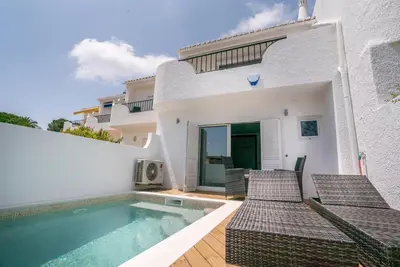 a white house with a swimming pool and chairs at ATLANTIC VIEW Apartment in Luz