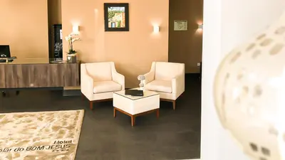 a living room with two chairs and a table at Hotel Solar Bom Jesus in Santa Cruz