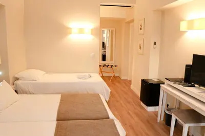 a hotel room with two beds and a television at Hotel Solar Bom Jesus in Santa Cruz