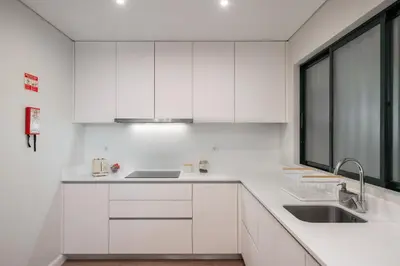 a white kitchen with white cabinets and a sink at Varandas do Funchal II by An Island Apart in Funchal