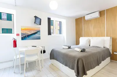 a white bedroom with a bed and a desk at Holiday Home Funchal Center in Funchal