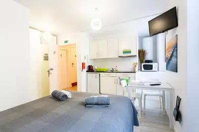 a white kitchen with a bed and a table at Holiday Home Funchal Center in Funchal