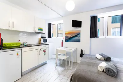 a white kitchen with a bed and a table at Holiday Home Funchal Center in Funchal