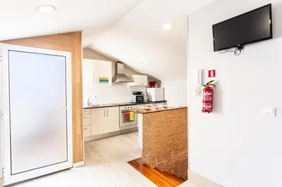 a kitchen with white cabinets and a flat screen tv at Holiday Home Funchal Center in Funchal