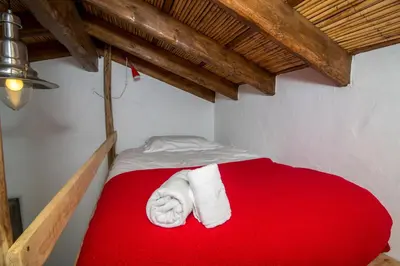 a bed with two towels on a red blanket at Casa Fajara in Carrapateira