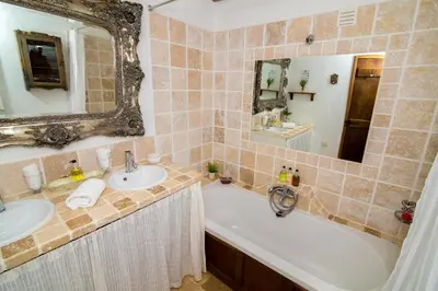 a bathroom with two sinks and a tub and a mirror at Casa Fajara in Carrapateira