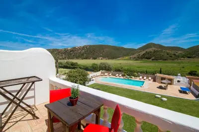 a villa with a swimming pool and mountains in the background at Casa Fajara in Carrapateira