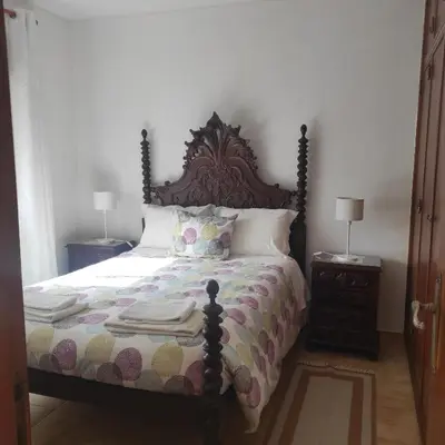 a bedroom with a large bed with two night stands at Casa Furtado in Burgau
