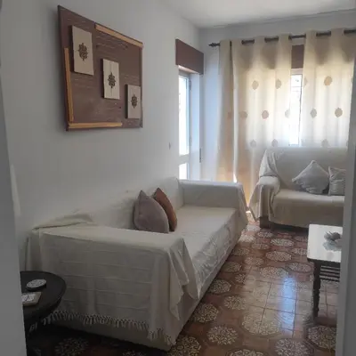 a living room with a white couch and a table at Casa Furtado in Burgau