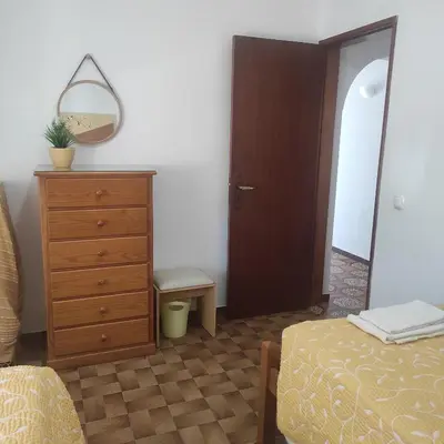a bedroom with a dresser and a mirror and a bed at Casa Furtado in Burgau