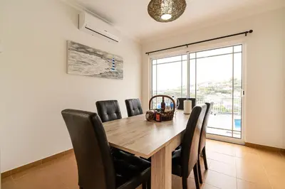 a dining room with a wooden table and chairs at Casa Agrela by Rent2U, Lda Swimming Pool & Jacuzzi in Calheta