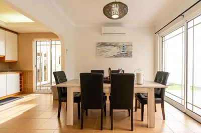 a kitchen and dining room with a table and chairs at Casa Agrela by Rent2U, Lda Swimming Pool & Jacuzzi in Calheta