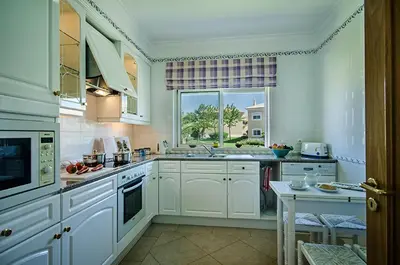 a large kitchen with white cabinets and a window at Luz casas- 44 Fairview village Boavista in Lagos